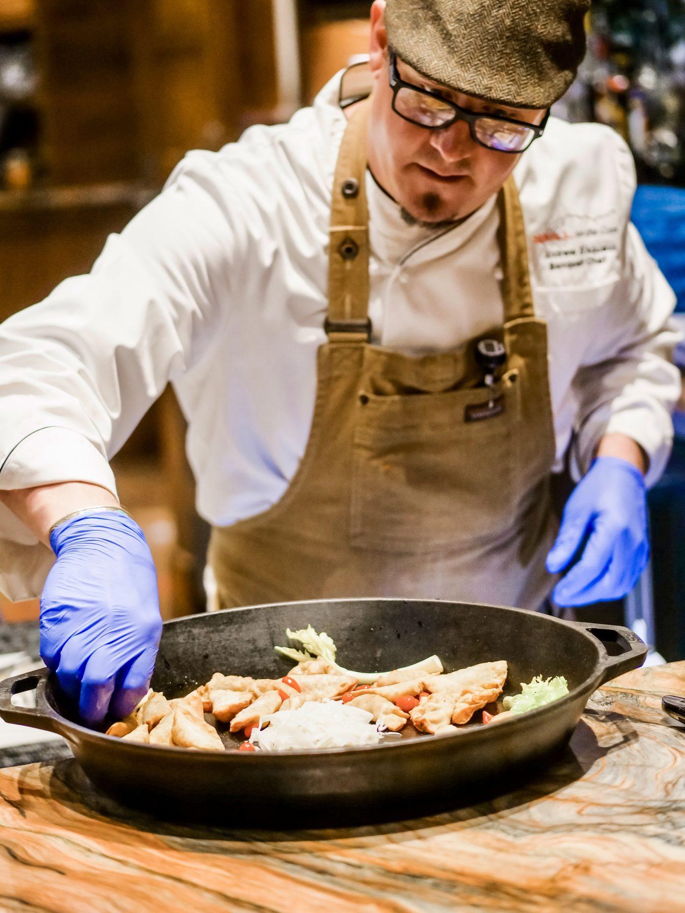 Chef Andrew D’Aquanni plating a dish tableside
